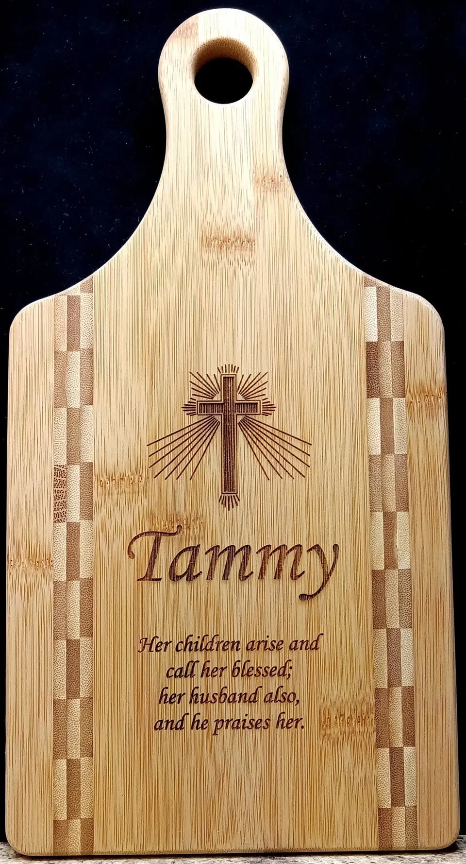 Bamboo cutting board engraved with a cross and a name