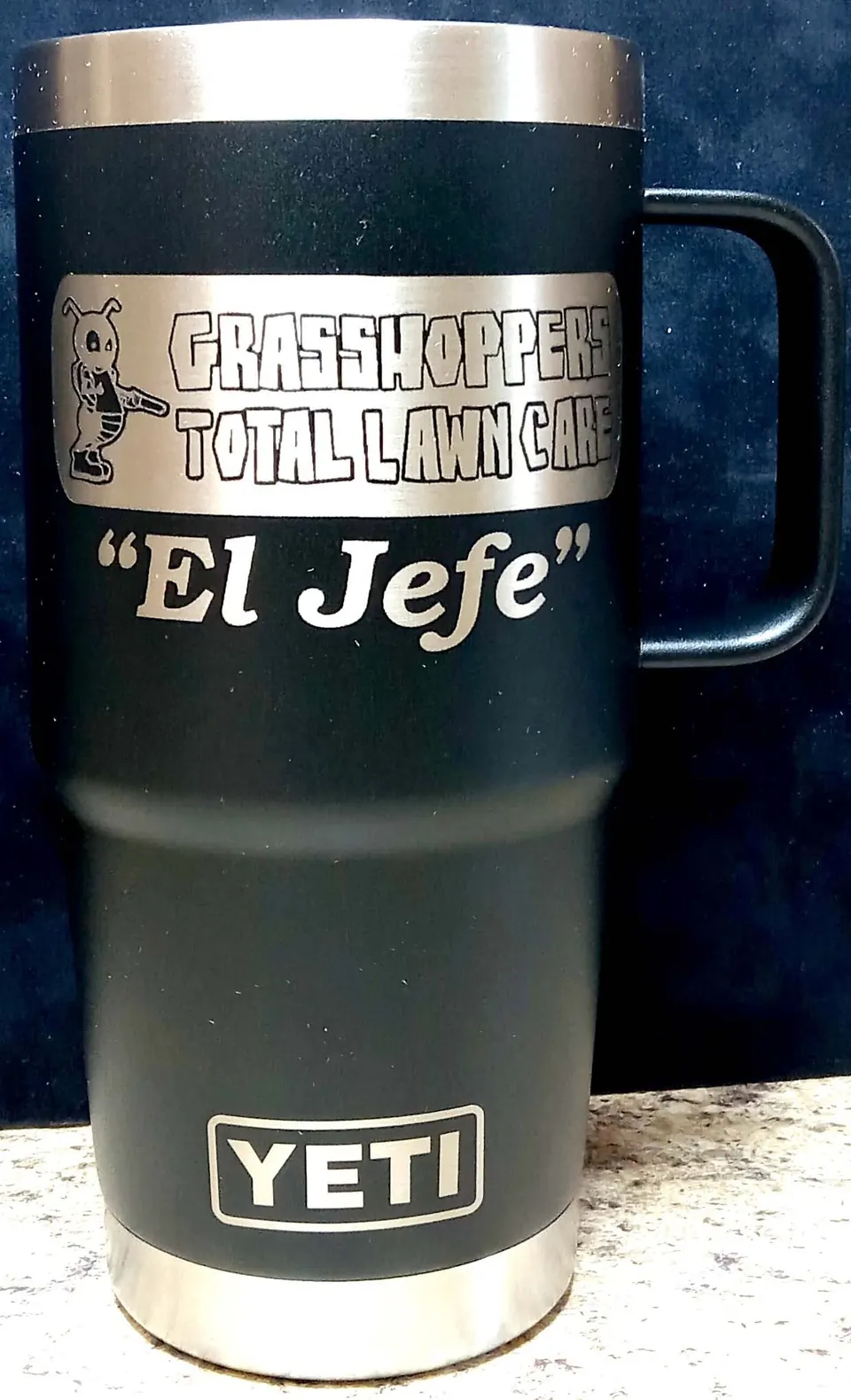 Black insulated mug engraved with a company logo