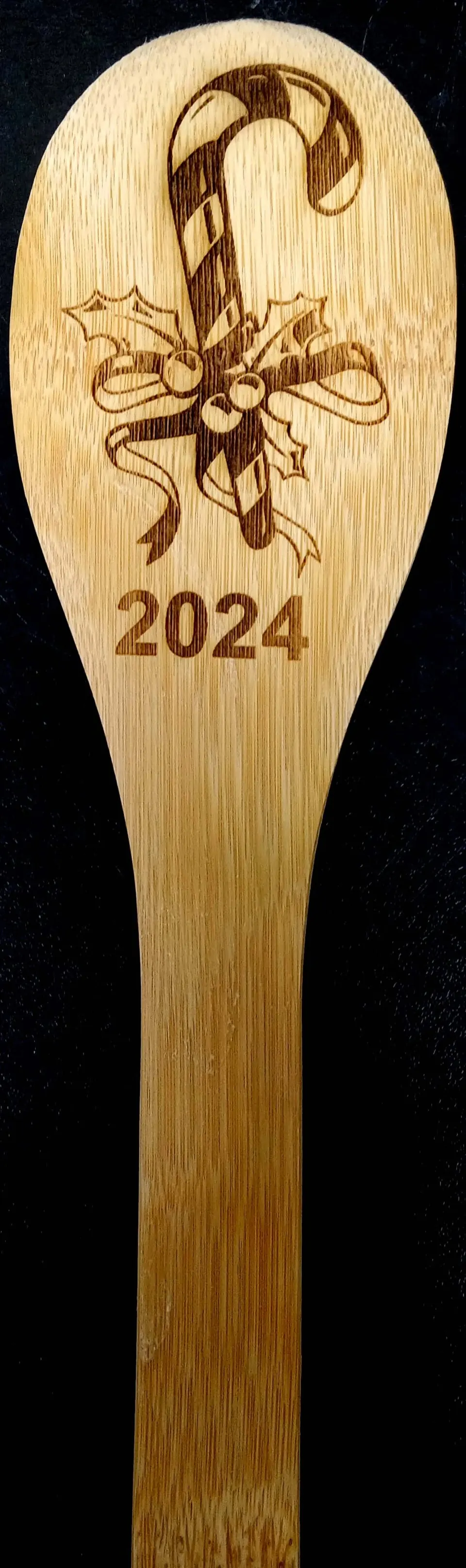 Wooden spoon engraved with a candy cane and 2024
