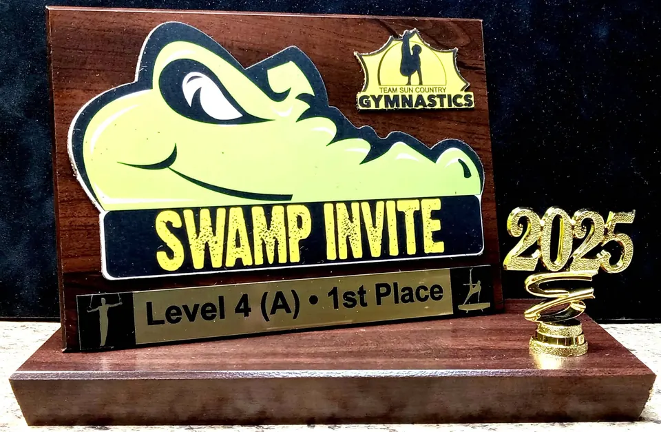 Swamp Invite gymnastics first place award with a 2025 topper